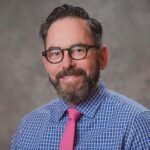 Benjamin Hazelton, project director for Oregon's MIECHV program, in front of gray background