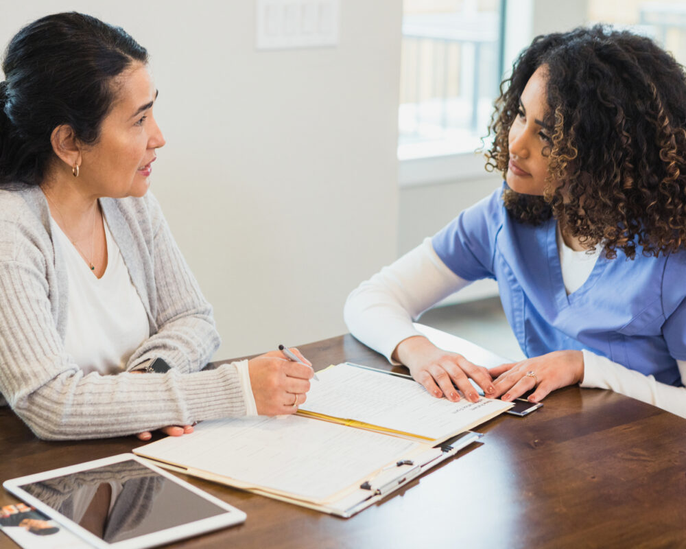 Consultant reviews document with nurse home visitor