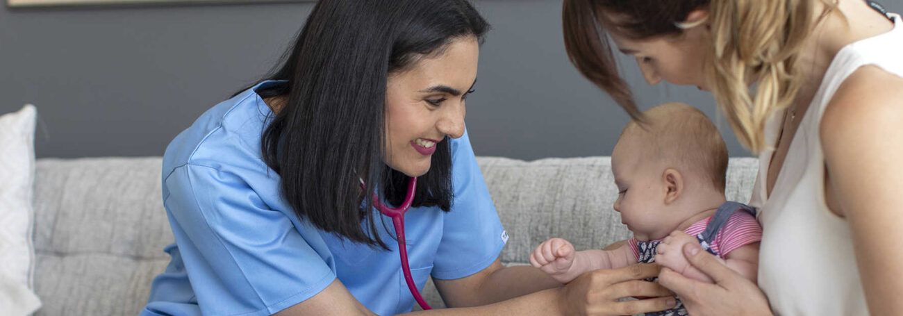 nurse visitor checks baby's heartbeat